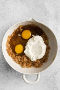 two eggs and whipped cream in a white bowl.