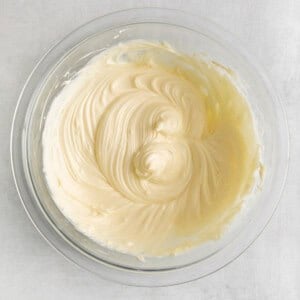 whipped cream in a glass bowl on a white background.