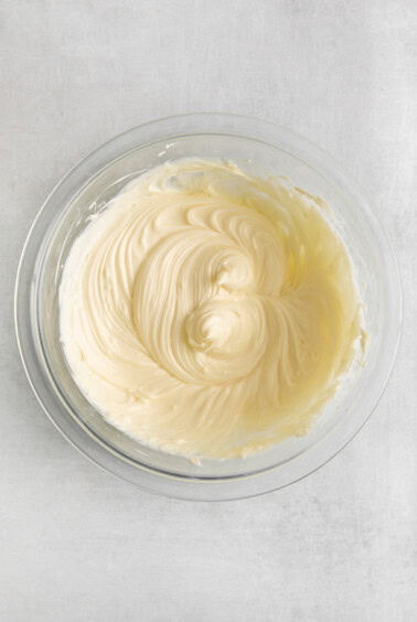 whipped cream in a glass bowl on a white background.