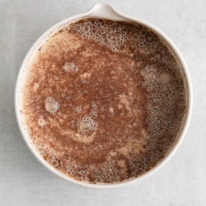 a white bowl with a brown liquid in it.