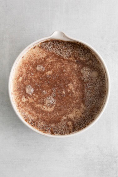 a white bowl with a brown liquid in it.
