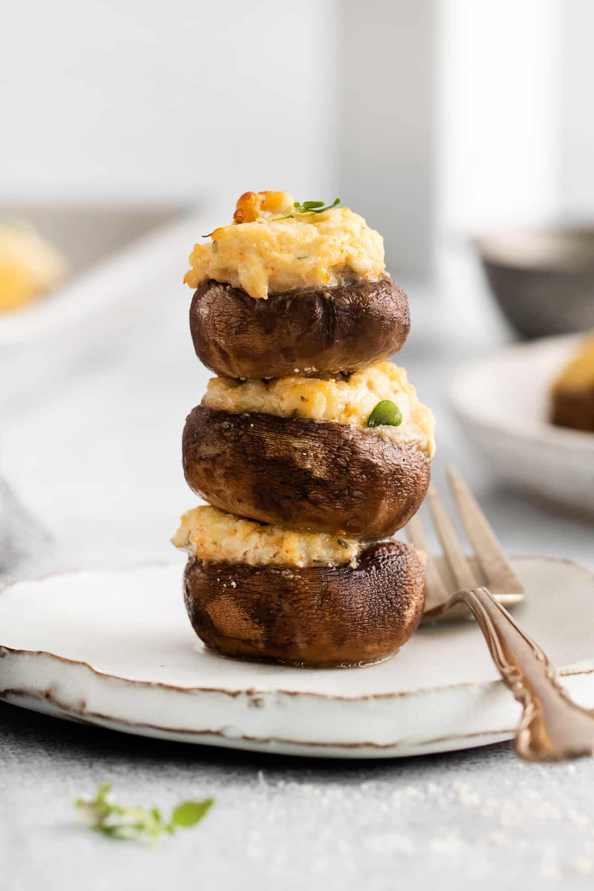 Crab stuffed mushrooms stacked on a plate.