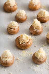 cheesy stuffed mushrooms on a baking sheet.