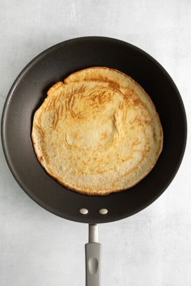 a pancake in a frying pan on a white background.