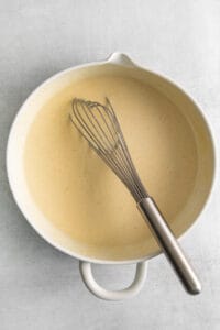 a white bowl with a whisk in it.