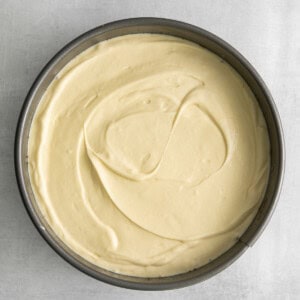 a white cake in a pan on a grey background.