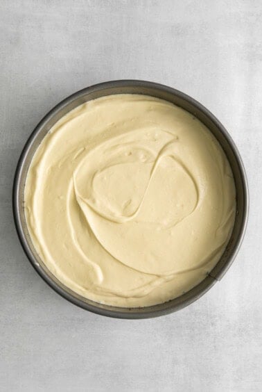 a white cake in a pan on a grey background.