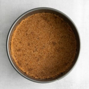 a brown crusted pie in a pan on a white surface.