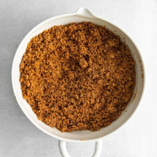 a white dish filled with a mixture of brown sugar and cinnamon.