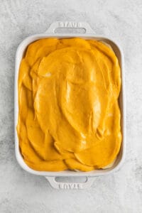 Scalloped potatoes topped with cheese sauce.