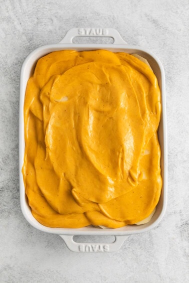 Scalloped potatoes topped with cheese sauce.