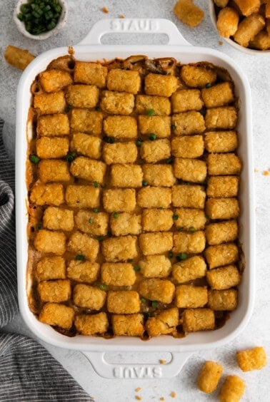 tater tot casserole in a white baking dish.