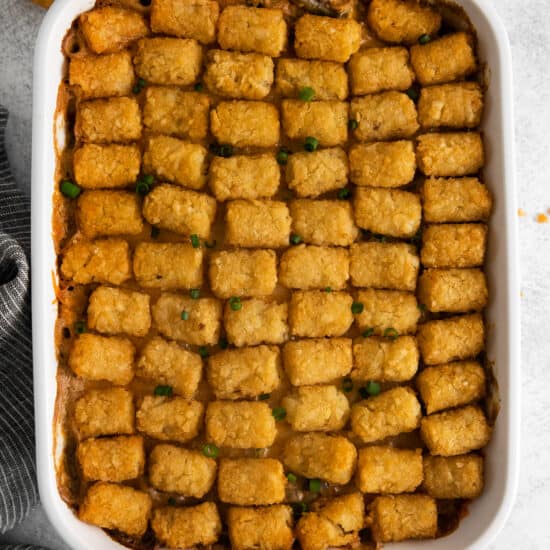 tater tot casserole in a white baking dish.