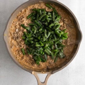 a skillet filled with mushrooms and green beans.