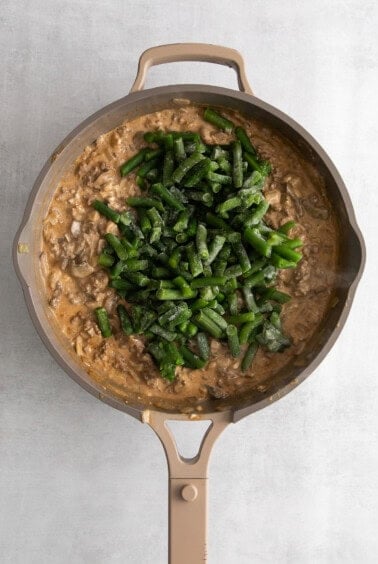 a skillet filled with mushrooms and green beans.