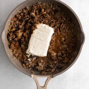 a skillet filled with mushrooms and cheese.