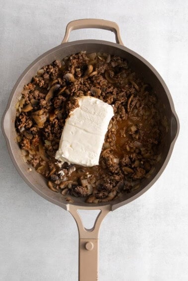 a skillet filled with mushrooms and cheese.