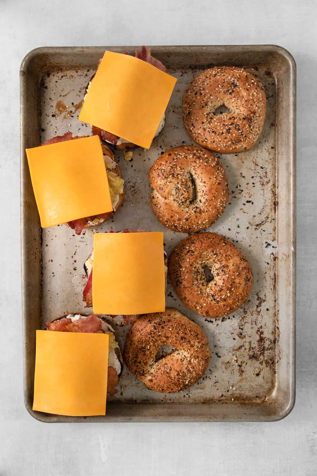 Bagels and cheese on a baking sheet. 