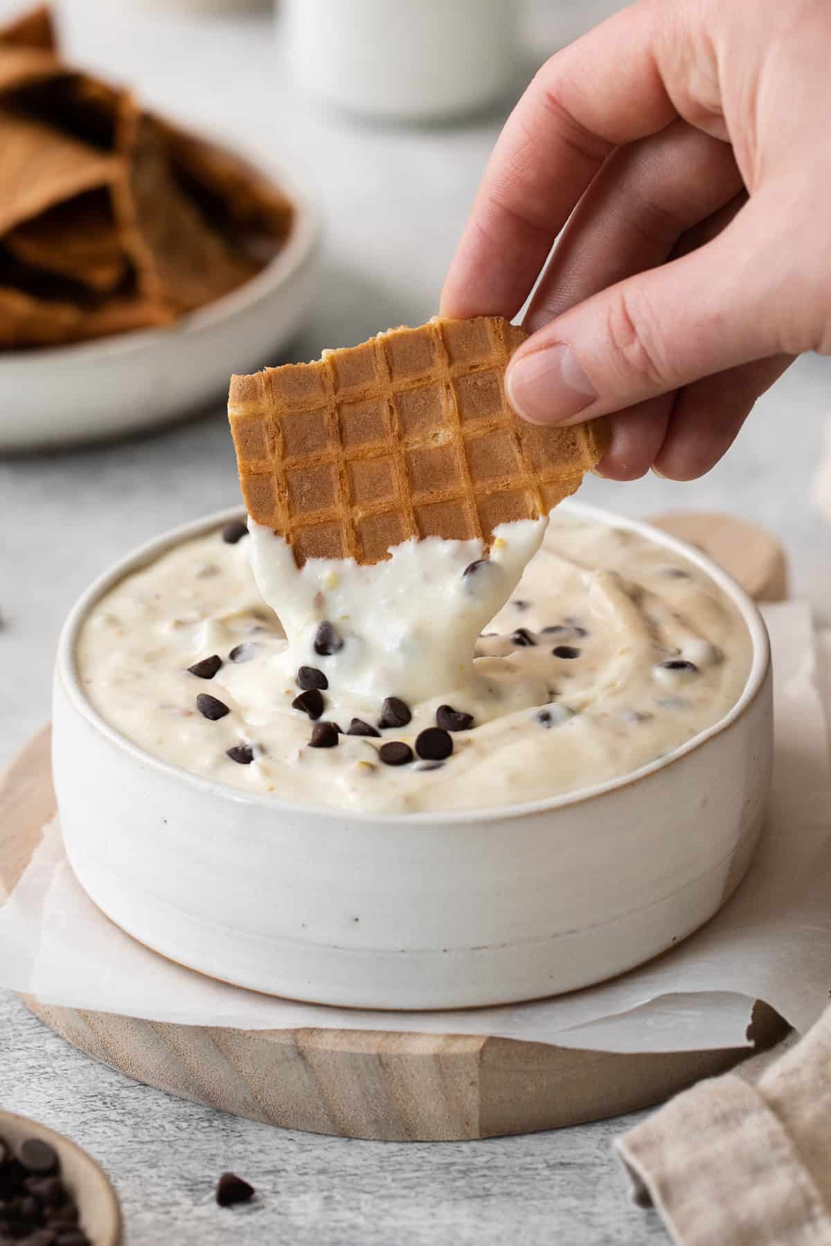 Dipping a waffle cone piece into cannoli dip. 