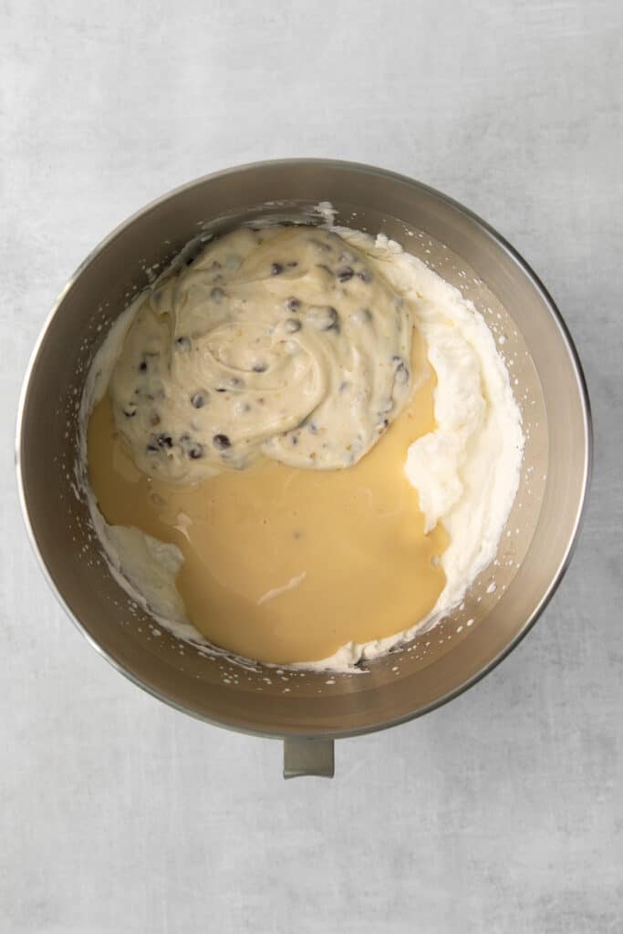 Sweet and condensed milk, cannoli dip, and whipped cream in a bowl.