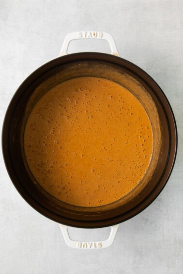 a slow cooker filled with a sauce.