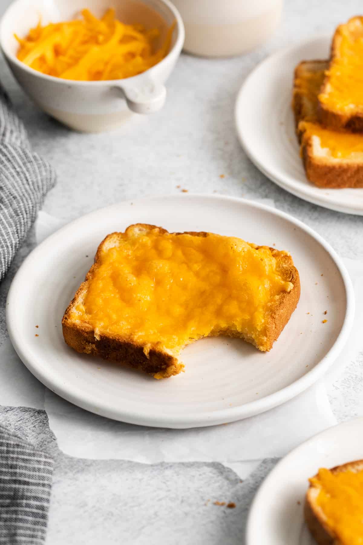 Cheese toast with a bite taken out of it.