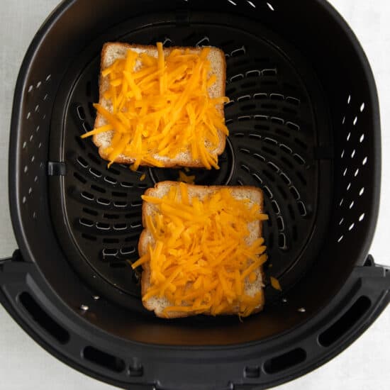 two slices of bread and cheese in an air fryer.