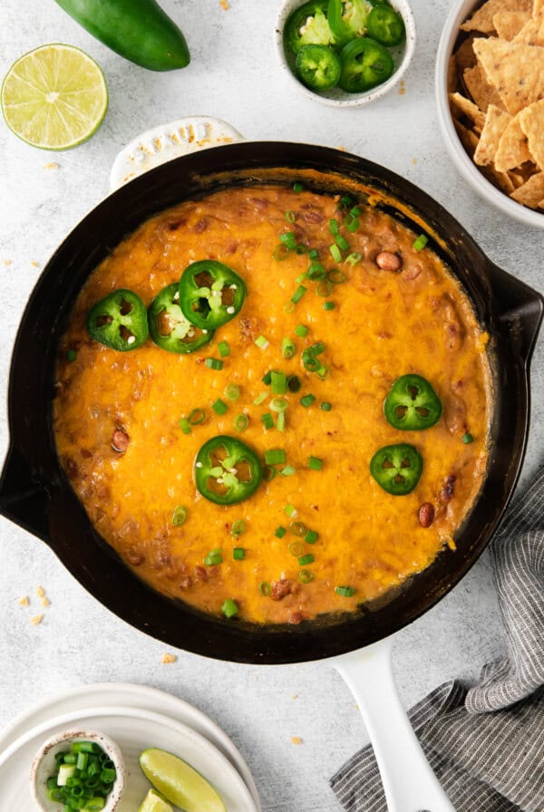 Cheesy bean dip in a cast iron skillet.