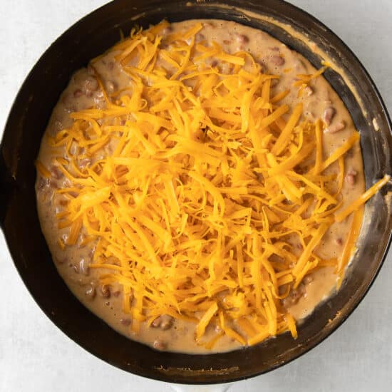 a skillet filled with cheesy beans and cheese.