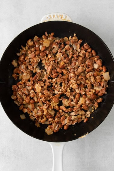 a frying pan filled with nuts and onions.