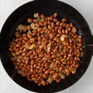 a skillet filled with beans and onions.