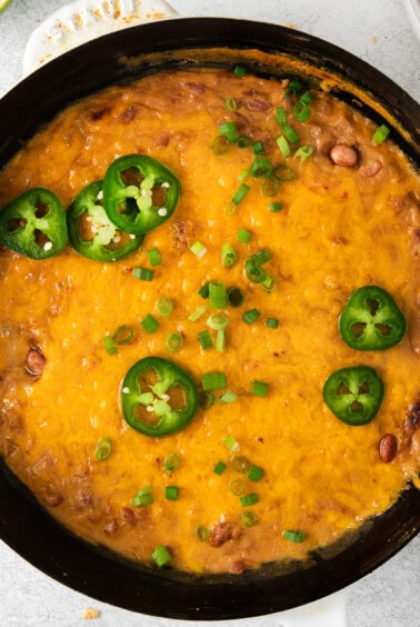 Cheesy bean dip in a cast iron skillet.
