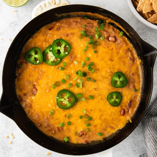 Cheesy bean dip in a cast iron skillet.