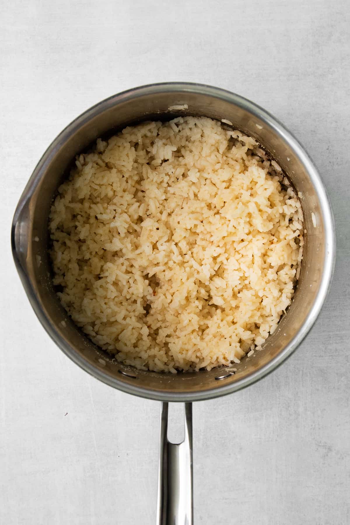 Cheese rice cooked in a sauce pan.