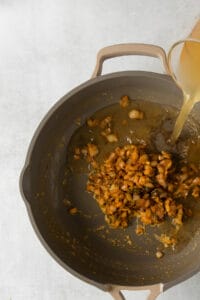a pan with a sauce being poured into it.