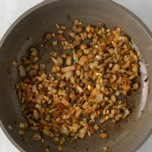 fried onions in a skillet on a white surface.