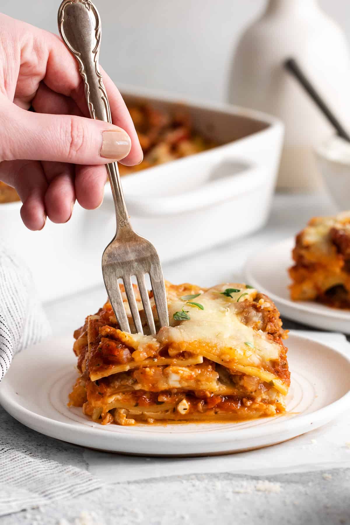 A fork taking a bite of lasagna. 
