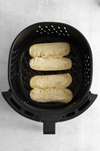 a black air fryer with two slices of bread in it.