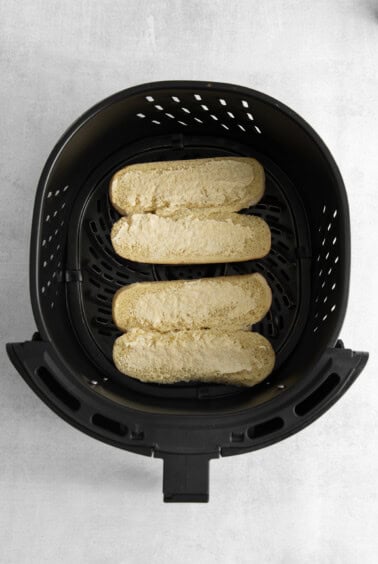 a black air fryer with two slices of bread in it.