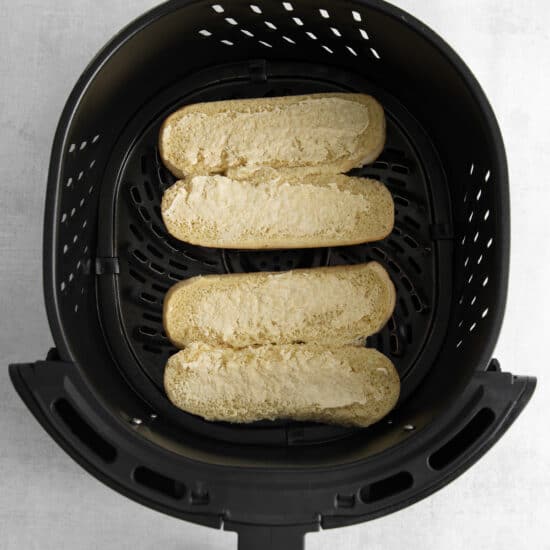 a black air fryer with two slices of bread in it.