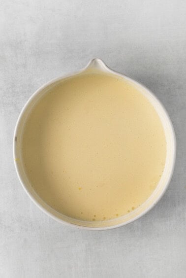 a white dish with a yellow liquid in it.