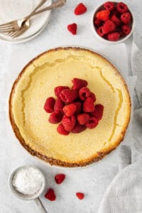 a slice of cheesecake with raspberries on top.