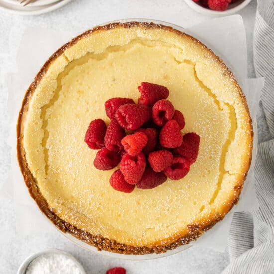 a slice of cheesecake with raspberries on top.