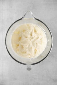 whipped cream in a glass bowl on a gray background.