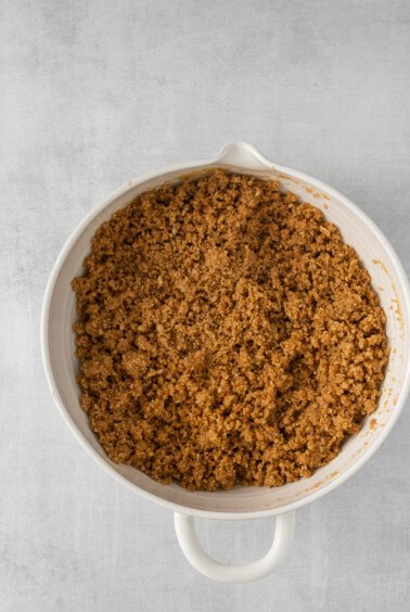 a white dish with a brown crumble in it.