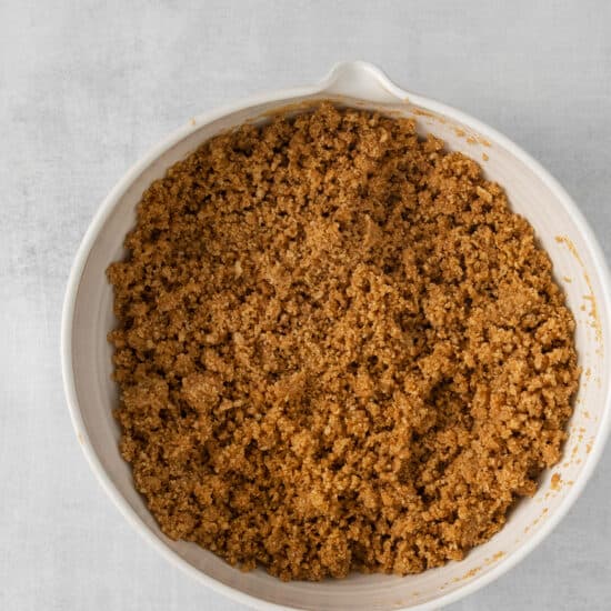 a white dish with a brown crumble in it.