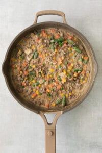 a skillet filled with vegetables and meat.