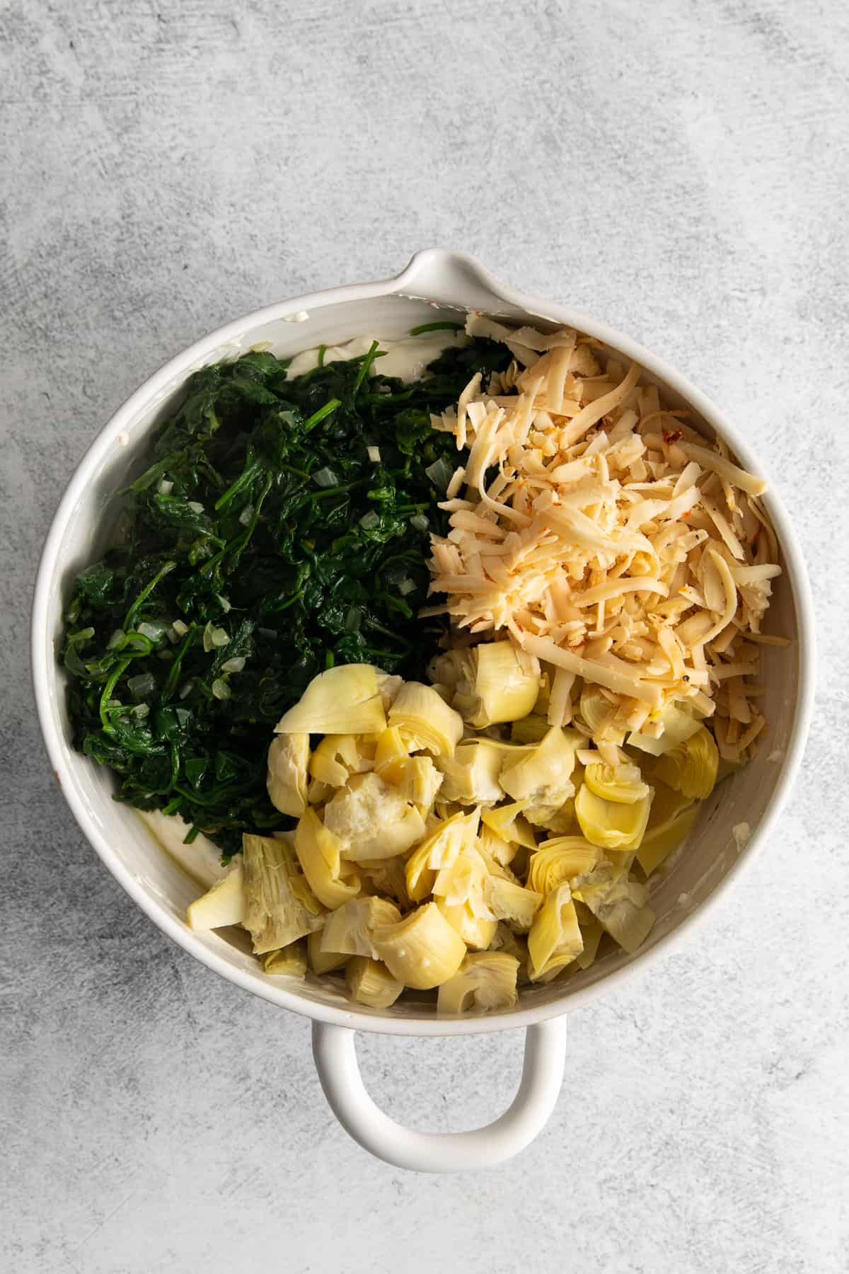 Spinach artichoke dip ingredients in a bowl.