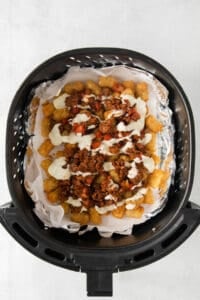 an air fryer filled with nachos and cheese.