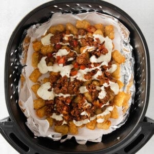 an air fryer filled with nachos and cheese.